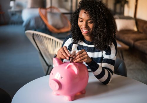 Black woman with saving piggy bank